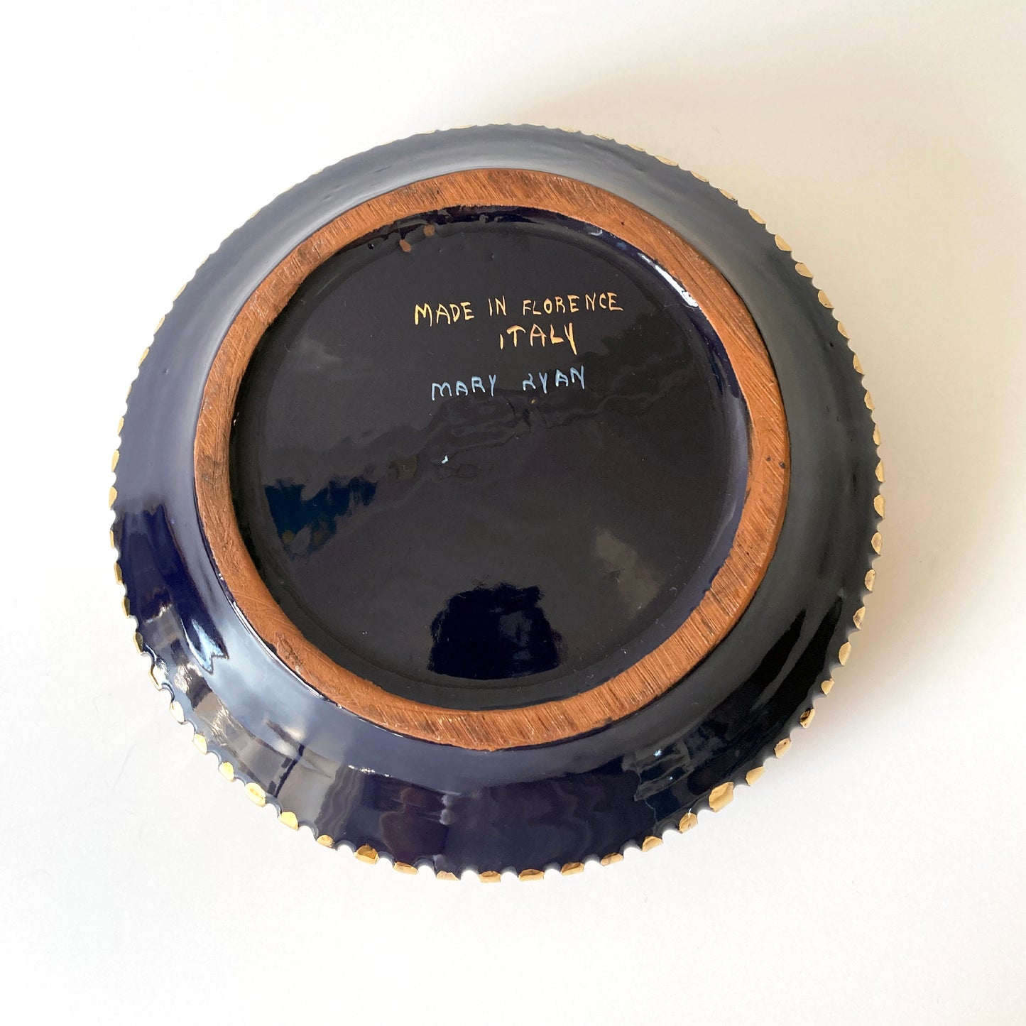 Beautiful Italian navy and gold round lidded box. The dark blue shade contrasts beautifully with the gold ribbed accents along the sides and on the finial. The size makes this piece versatile, as a jewelry box or catchall. This box looks great as part of a group, or independently on a dresser or side table. Signed: Mary Ryan, Made in Florence Italy