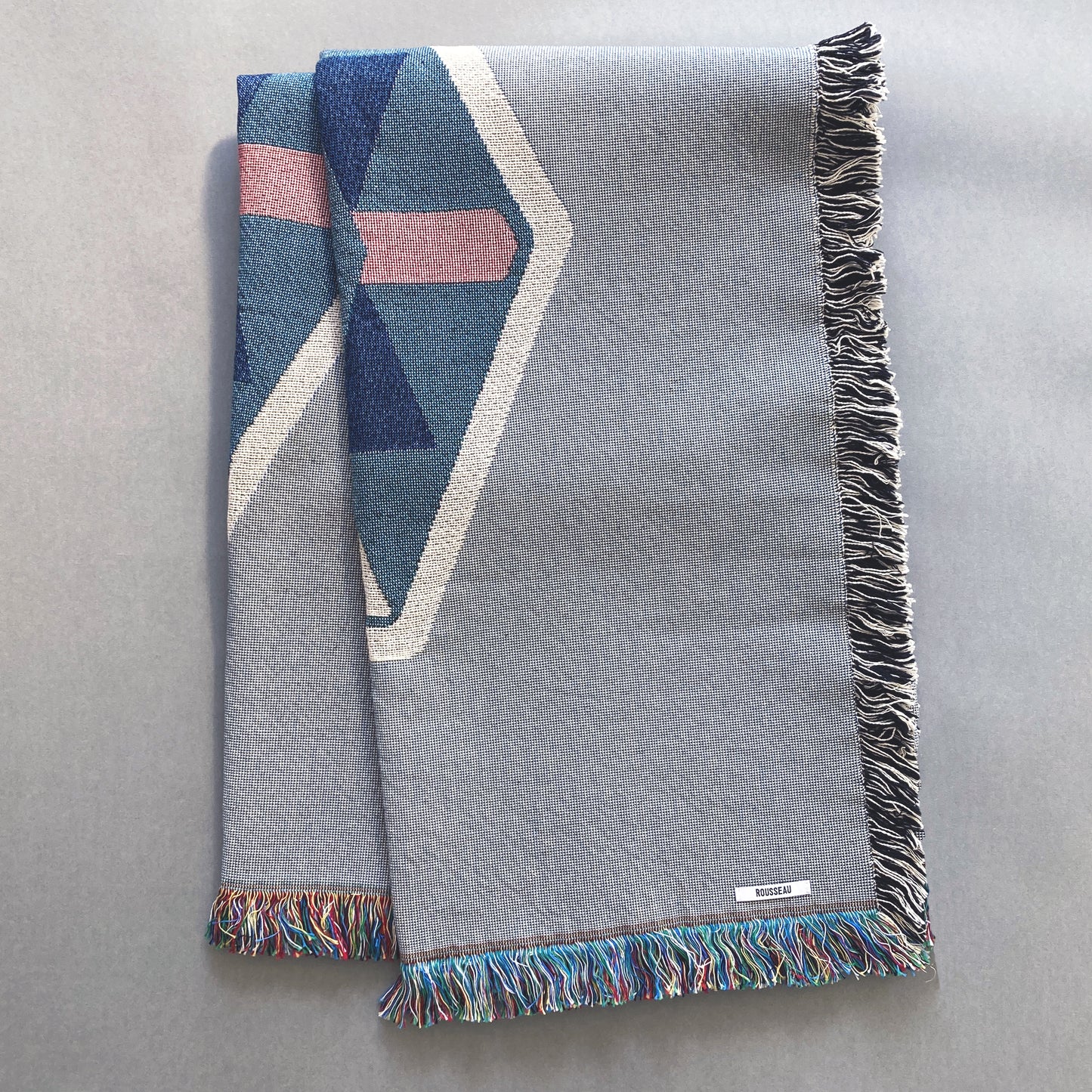Fog gray geo woven throw with fringe edge. Woven with recycled cotton on a jacquard loom, made in the US. Each throw measures 54 x 72 inches.