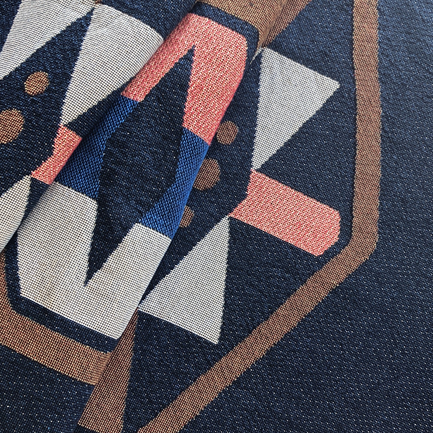Detail of twilight navy geo woven throw with fringe edge. Woven with recycled cotton on a jacquard loom, made in the US. Each throw measures 54 x 72 inches.