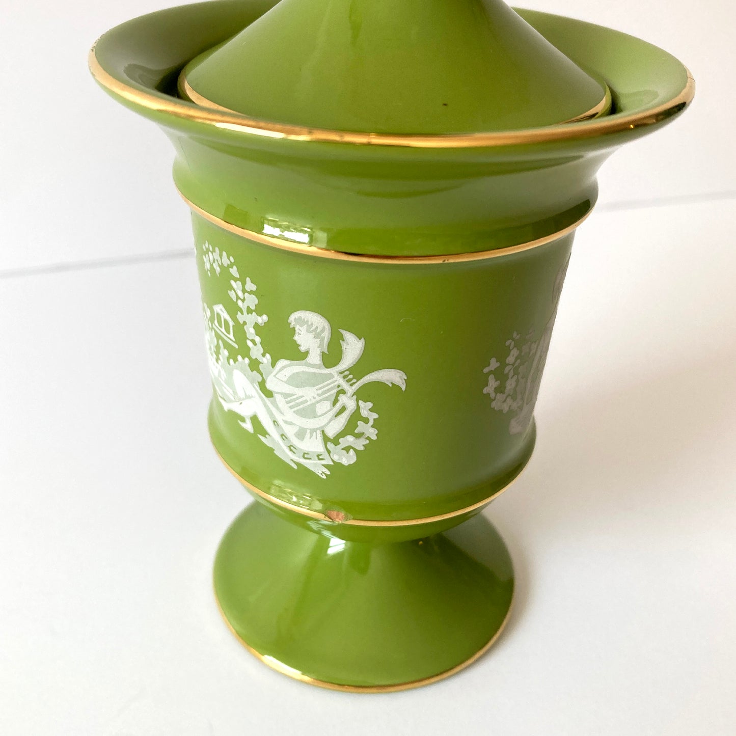 Beautiful Italian moss green and gold round lidded ceramic jar/ urn. The green shade contrasts beautifully with the gold accents and white pattern that wraps around the piece. The petite size makes this piece versatile, this piece looks great as part of a group, or independently on a dresser or side table. Signed: Hand Made in Italy, Florentine, 7.