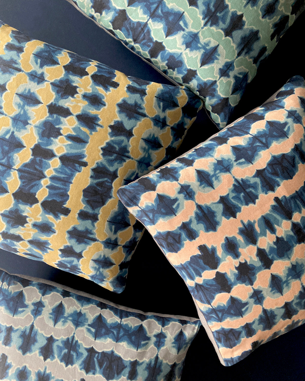 Patterned fabric with blue, pink, yellow, and green colors on a dark background