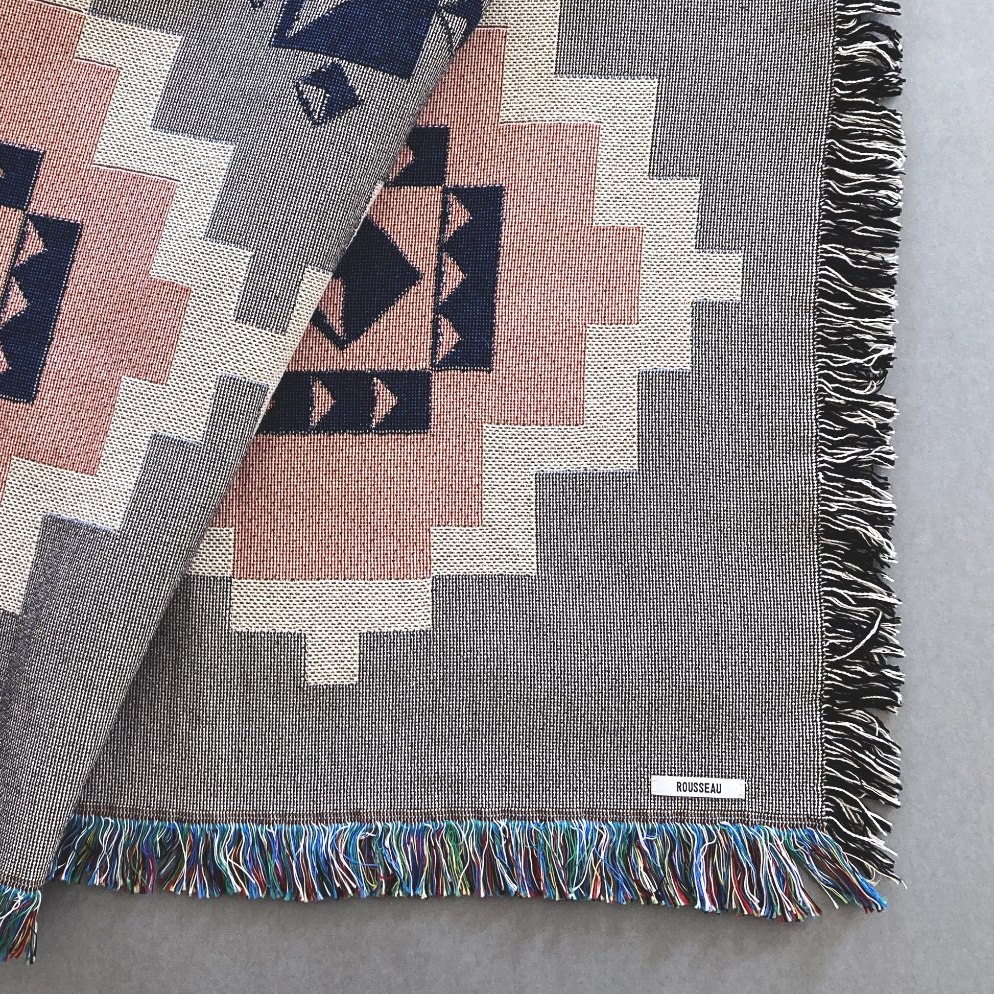 Detail of gray and pink geometric throw blanket, cotton