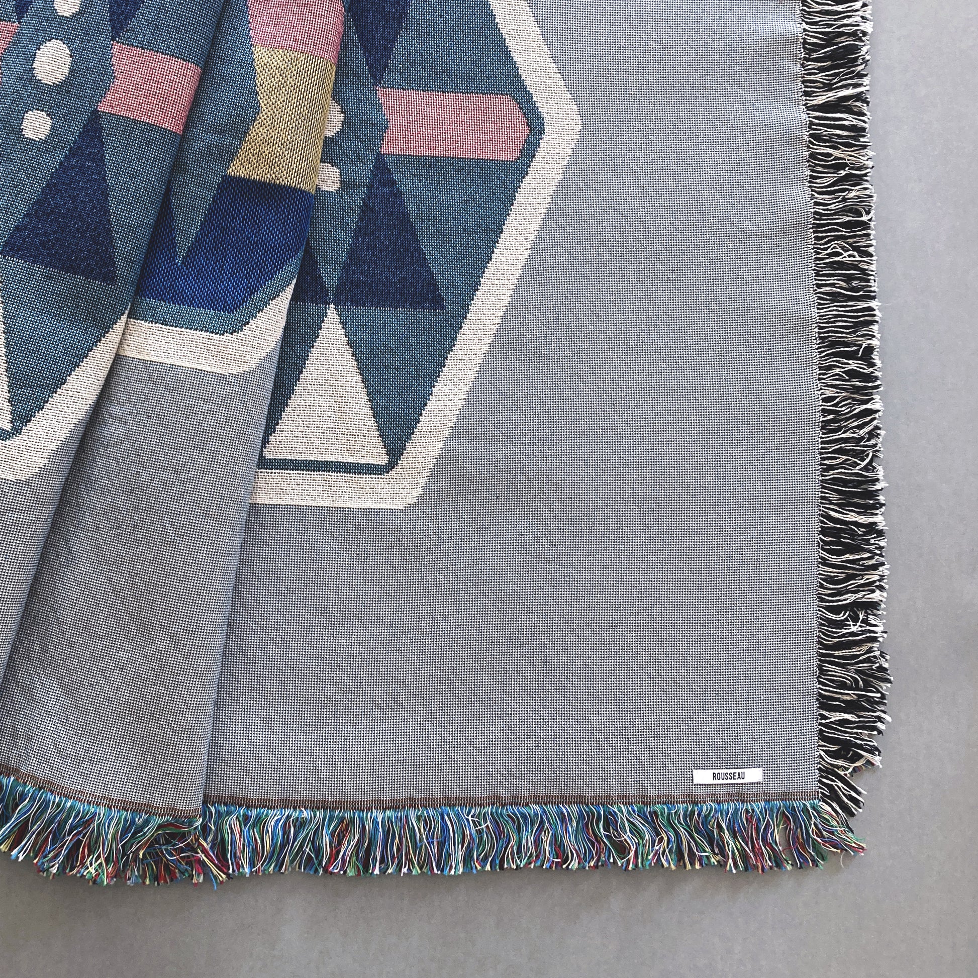 Fog gray geo woven throw with fringe edge. Woven with recycled cotton on a jacquard loom, made in the US. Each throw measures 54 x 72 inches.