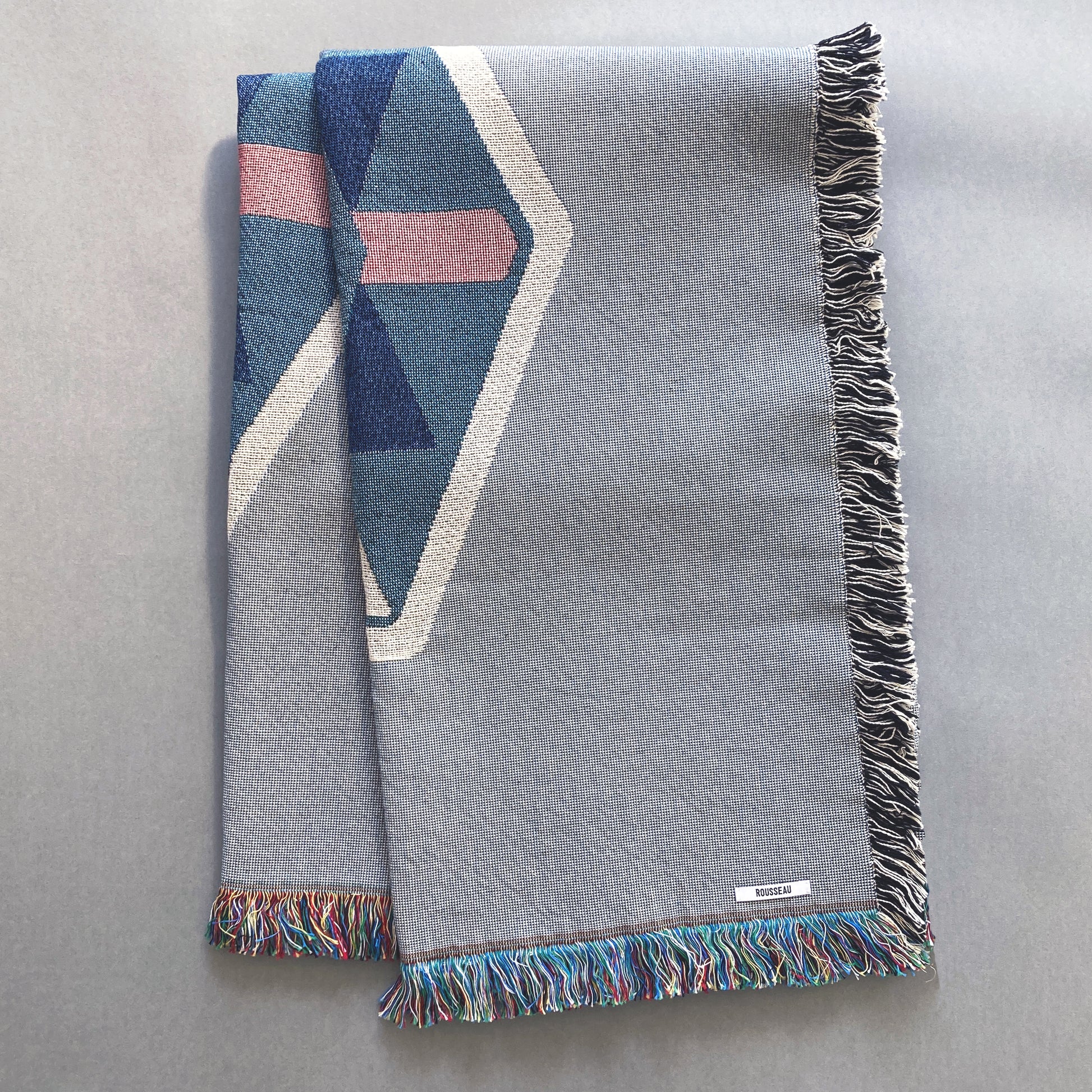 Fog gray geo woven throw with fringe edge. Woven with recycled cotton on a jacquard loom, made in the US. Each throw measures 54 x 72 inches.