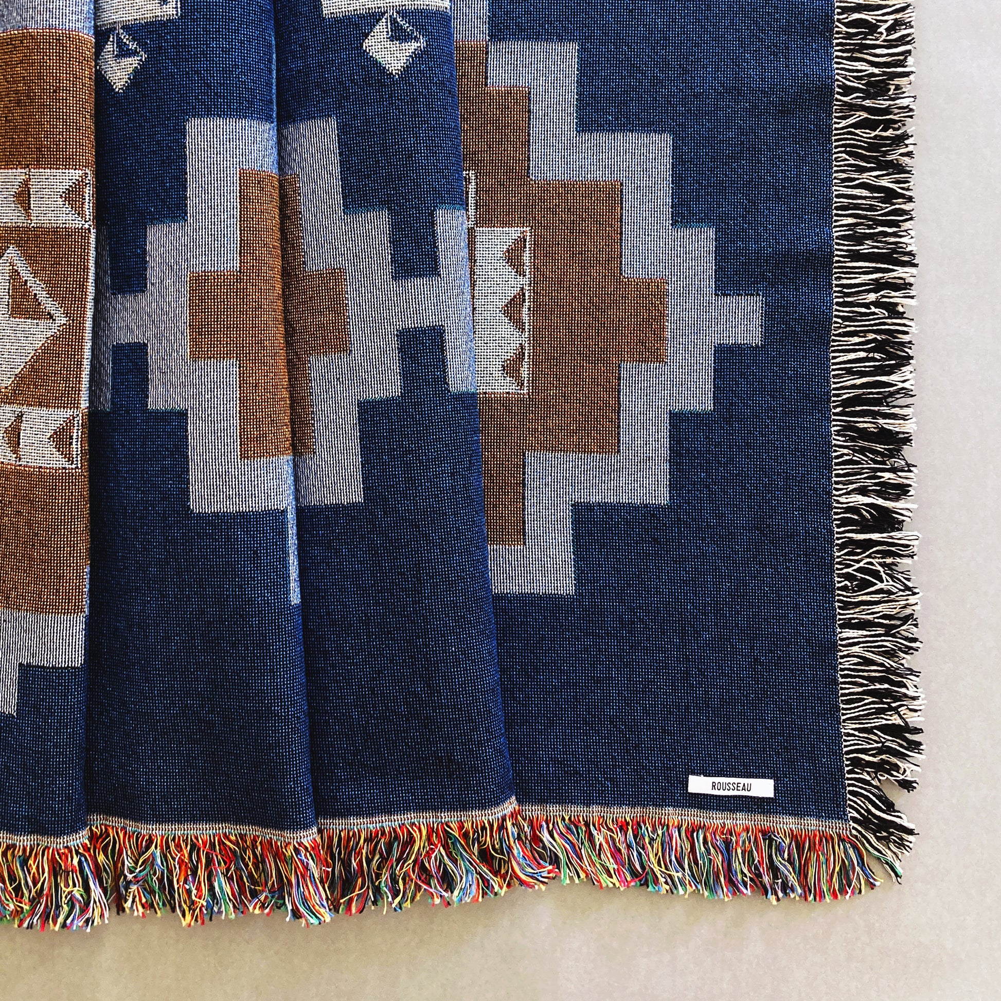 Navy and ochre geometric print woven throw with fringe edge. Woven with recycled cotton on a jacquard loom, made in the US. Each throw measures 54 x 72 inches.

This geometric patterned throw is inspired by early 20th century woven coverlets. The updated, bold geometric pattern offers a fresh perspective on a long-forgotten craft.
