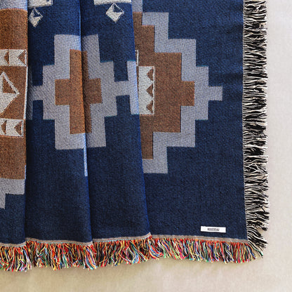 Navy and ochre geometric print woven throw with fringe edge. Woven with recycled cotton on a jacquard loom, made in the US. Each throw measures 54 x 72 inches.

This geometric patterned throw is inspired by early 20th century woven coverlets. The updated, bold geometric pattern offers a fresh perspective on a long-forgotten craft.
