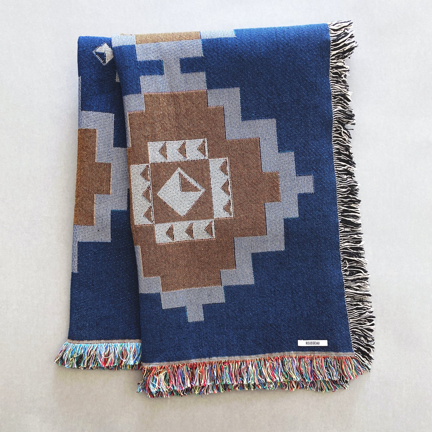 Navy and ochre geometric print woven throw with fringe edge. Woven with recycled cotton on a jacquard loom, made in the US. Each throw measures 54 x 72 inches.

This geometric patterned throw is inspired by early 20th century woven coverlets. The updated, bold geometric pattern offers a fresh perspective on a long-forgotten craft.
