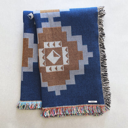 Navy and ochre geometric print woven throw with fringe edge. Woven with recycled cotton on a jacquard loom, made in the US. Each throw measures 54 x 72 inches.

This geometric patterned throw is inspired by early 20th century woven coverlets. The updated, bold geometric pattern offers a fresh perspective on a long-forgotten craft.
