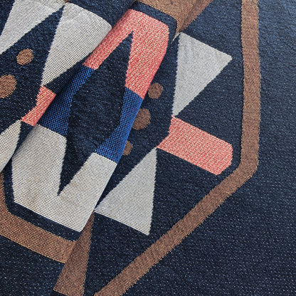 Detail of twilight navy geo woven throw with fringe edge. Woven with recycled cotton on a jacquard loom, made in the US. Each throw measures 54 x 72 inches.