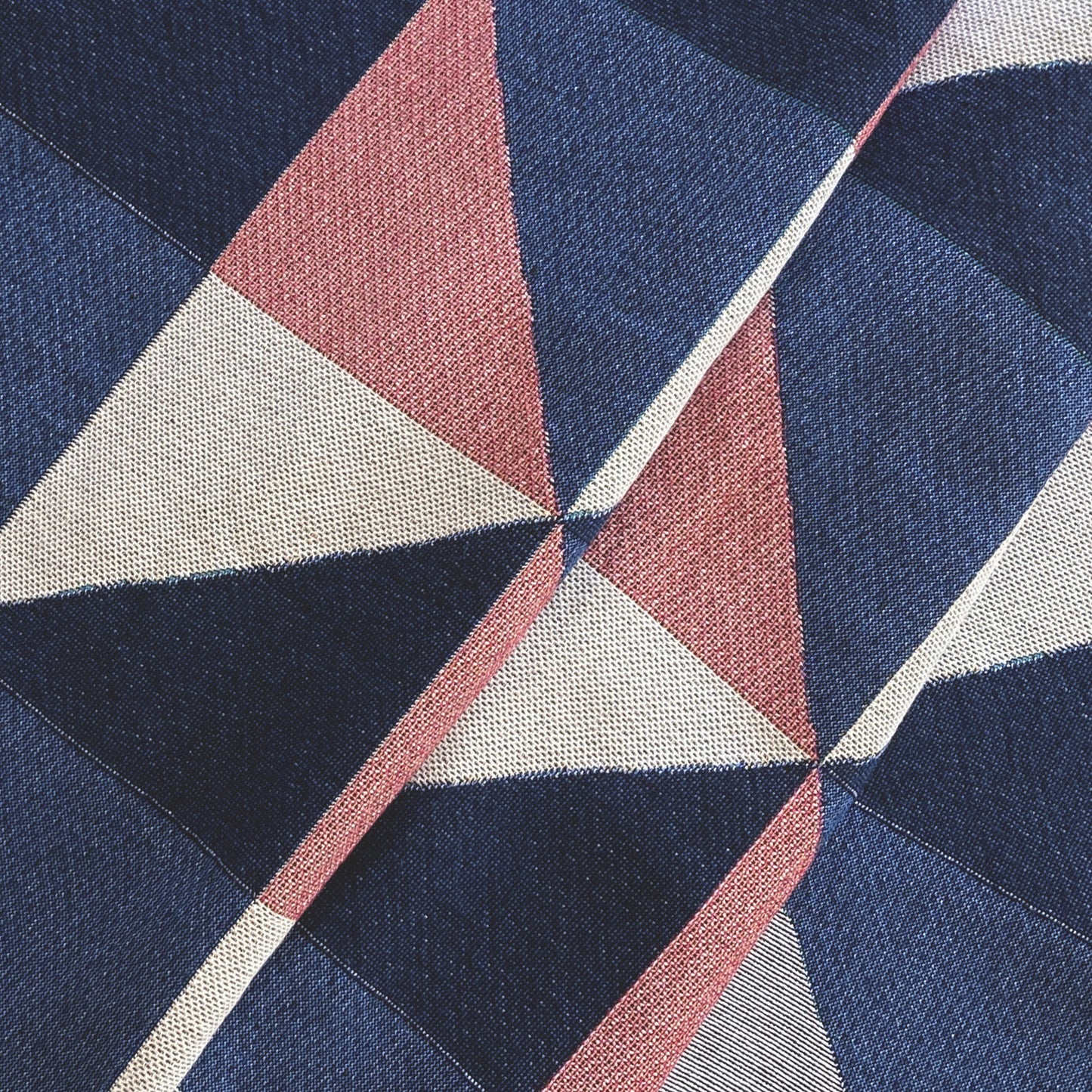 The Sixteen throw in navy, pink, ochre and gray geometric print woven throw with fringe edge. Woven with recycled cotton on a jacquard loom, made in the US. Each throw measures 54 x 72 inches.

This geometric patterned throw is inspired by a painting we created for our New York City studio.