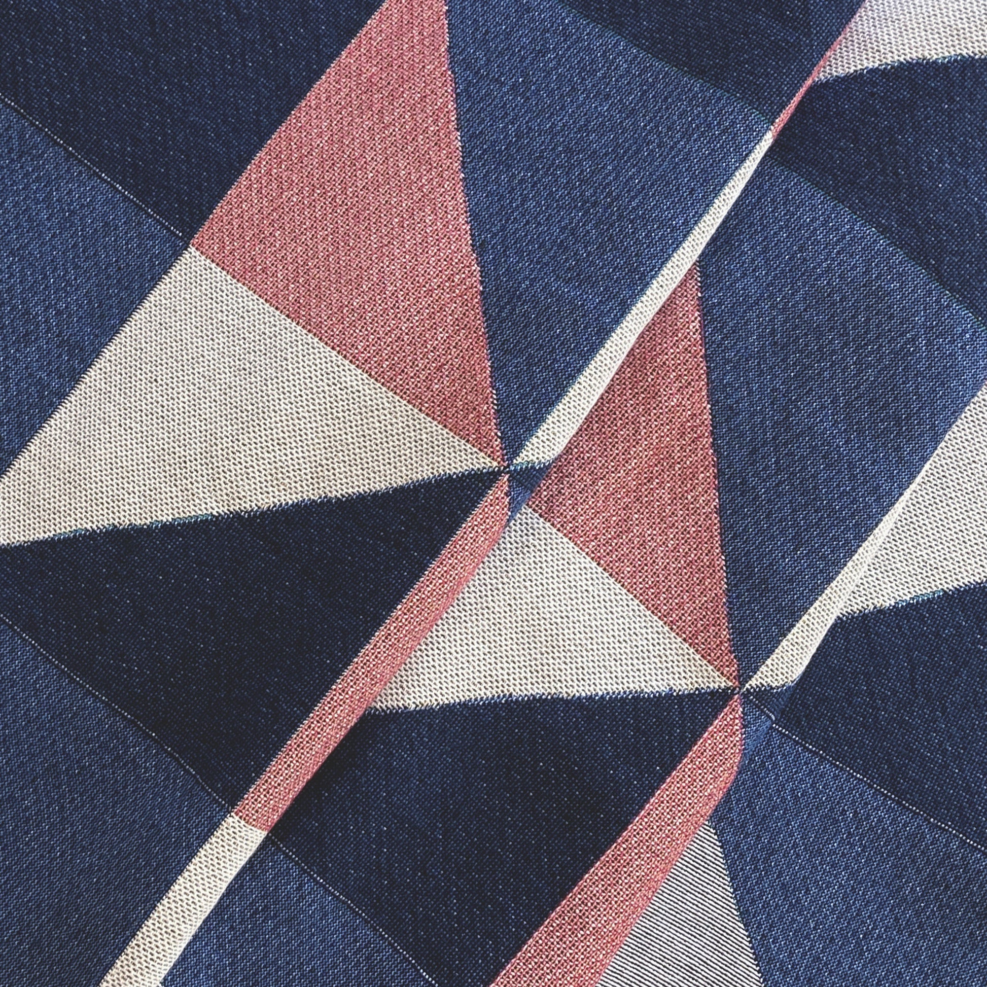 The Sixteen throw in navy, pink, ochre and gray geometric print woven throw with fringe edge. Woven with recycled cotton on a jacquard loom, made in the US. Each throw measures 54 x 72 inches.

This geometric patterned throw is inspired by a painting we created for our New York City studio.