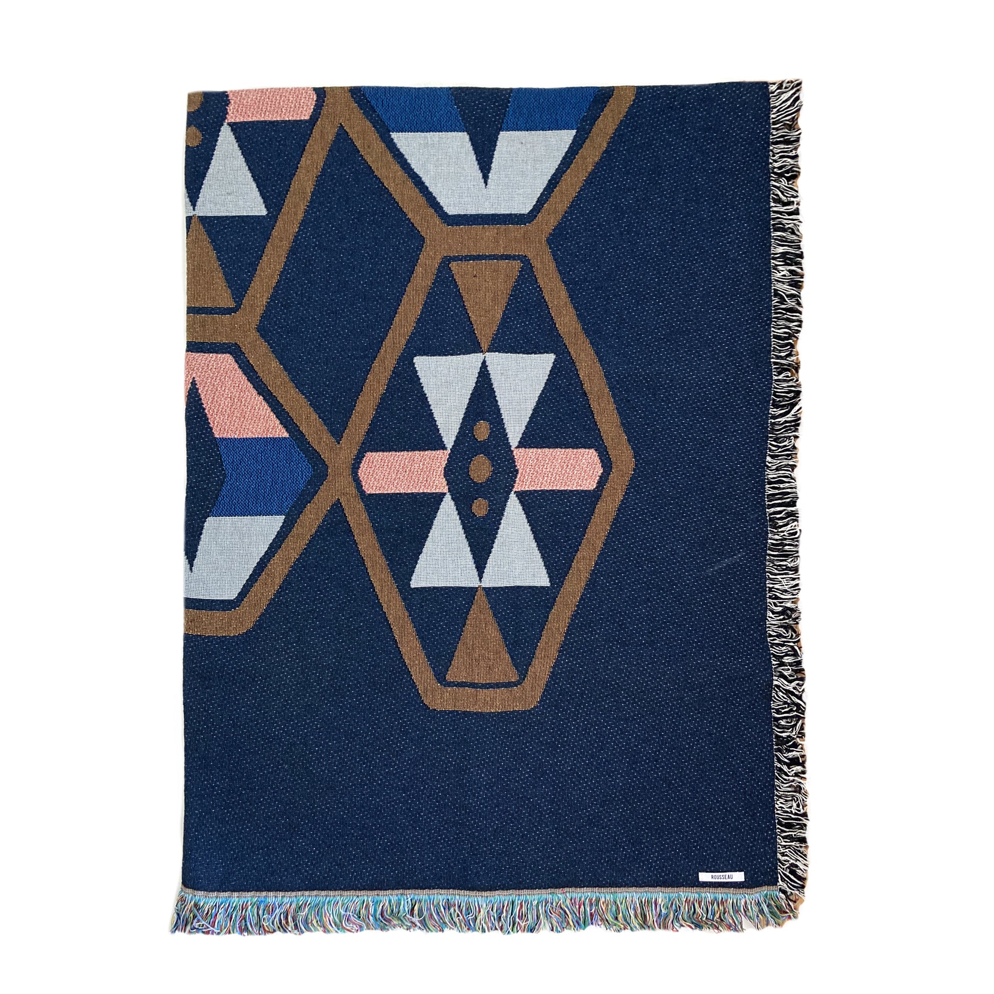 A woven cotton throw blanket with a geometric pattern in navy and contrasting colors, featuring a fringe edge.