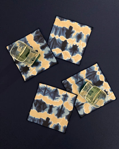Four tie-dye coasters with a dark background