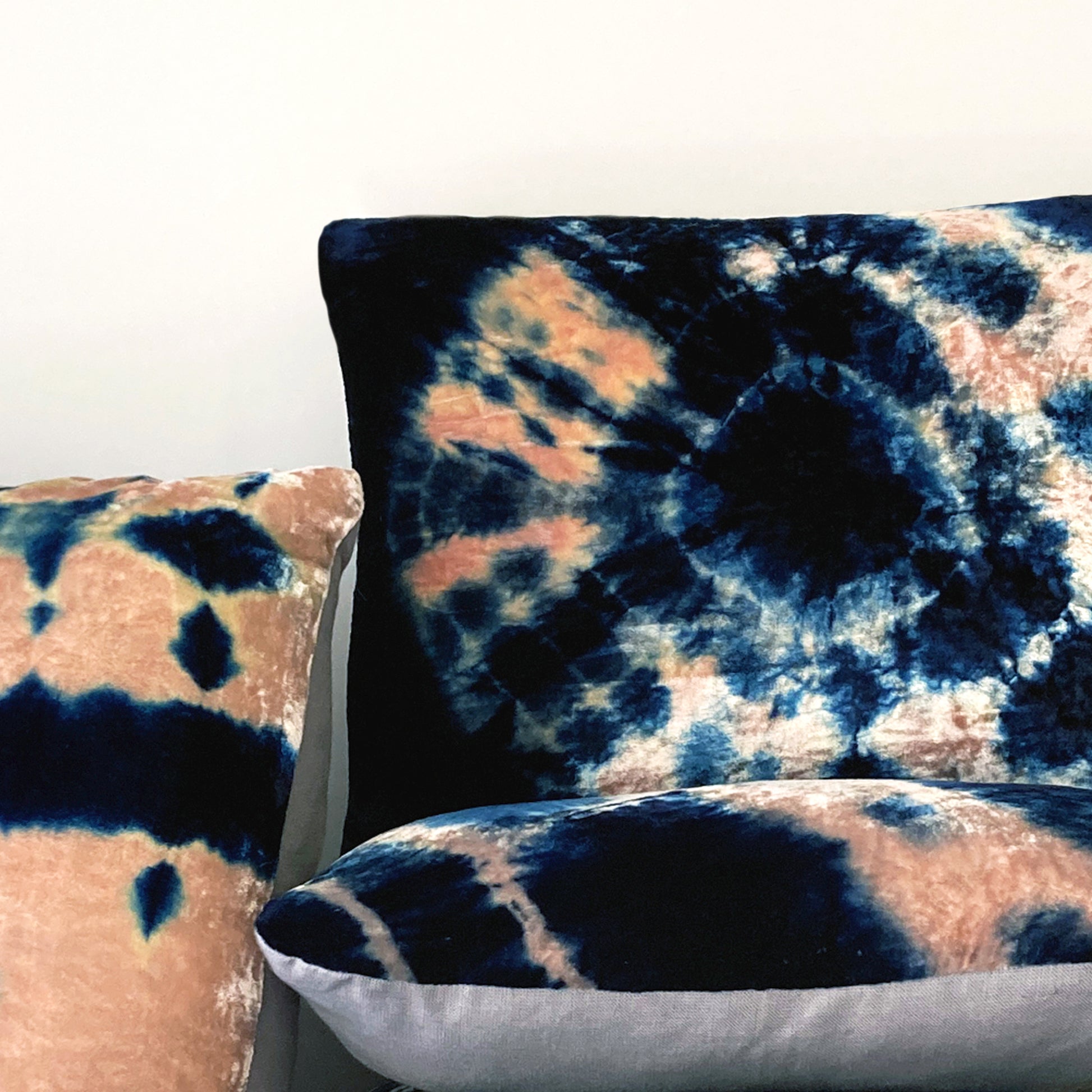 Grouping of rose and indigo velvet pillows in abstract patterns.