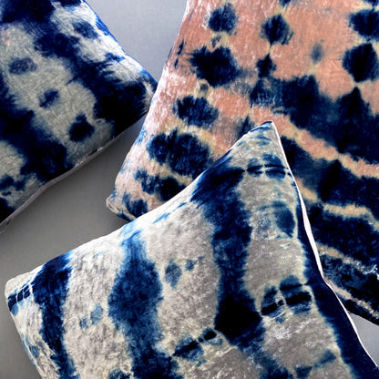 Grouping of silver, pink and indigo velvet pillows in abstract patterns.
