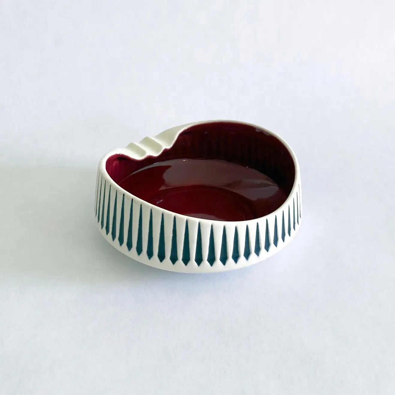 A vintage Hornsea Pottery ashtray with a bold red interior and white and black exterior designed by John Clappison.