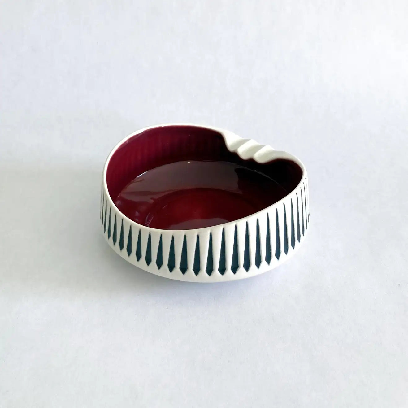 A vintage Hornsea Pottery ashtray with a bold red interior and white and black exterior designed by John Clappison.