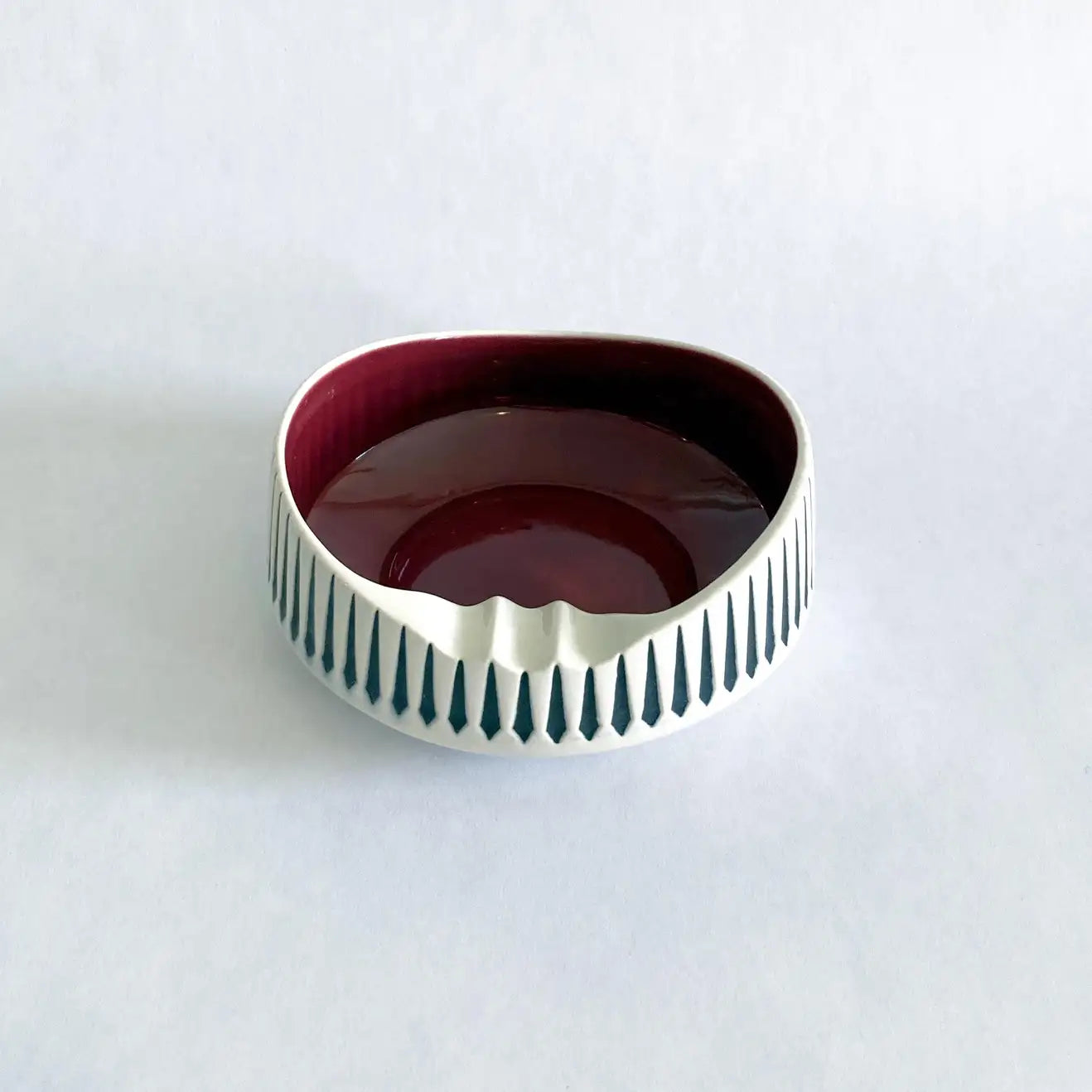 A vintage Hornsea Pottery ashtray with a bold red interior and white and black exterior designed by John Clappison.