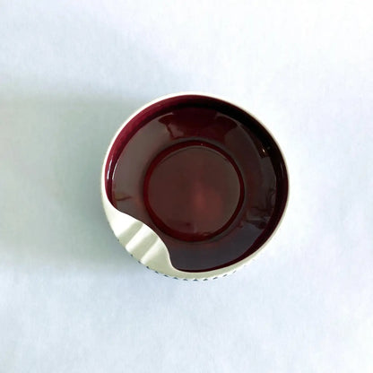 A vintage Hornsea Pottery ashtray with a bold red interior and white and black exterior designed by John Clappison.