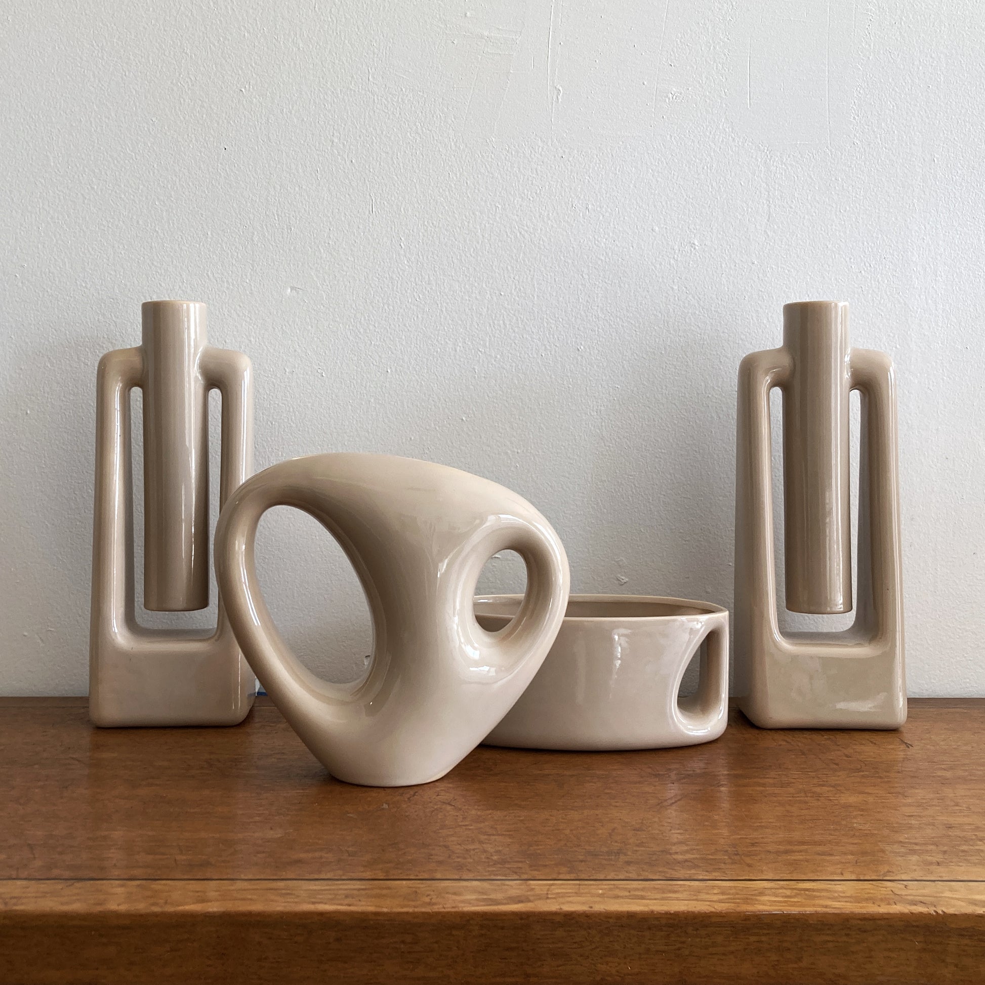 An oblong beige/ecru ceramic vase with a postmodern design, featuring a cut-out on the side.